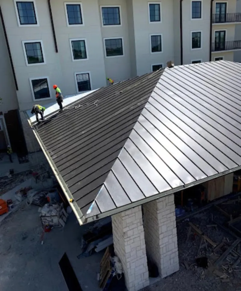 Crew installing standing seam metal roof panels on a commercial project in Upper Leacock